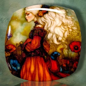 May include: A square decorative plate featuring a glossy illustration of a person with long, flowing white hair and a red dress standing in a field of vibrant red and blue flowers. The artwork displays a soft, painterly style with warm tones.