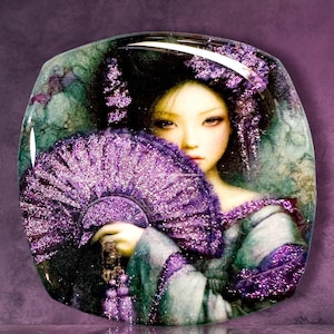 May include: A glossy, rounded rectangular plaque featuring a portrait of a person with dark hair adorned with purple glitter accents. The person holds a large, vibrant purple glitter folding fan that partially obscures their face and clothing.