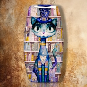 May include: A vertical oval-shaped decorative plaque featuring a blue cat wearing a blue top hat with floral patterns. The cat has large eyes, a heart shape on its chest, and is positioned in front of a background of shelves filled with books.