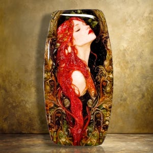 May include: A rectangular glass plaque featuring a profile illustration of a person with long, flowing red hair against a black background. The image is framed by intricate, swirling gold and green organic patterns with a glossy, reflective finish.