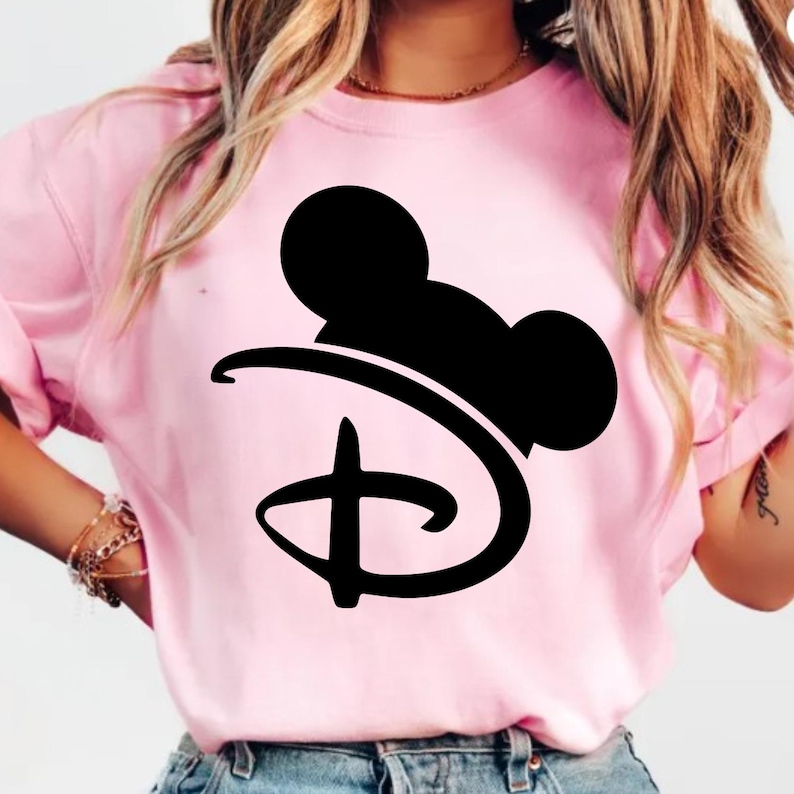 Pu&ograve; includere: T-shirt rosa chiaro con una silhouette nera di Mickey Mouse e il logo Disney. La maglietta ha maniche corte e girocollo. Il disegno &egrave; centrato sul davanti.