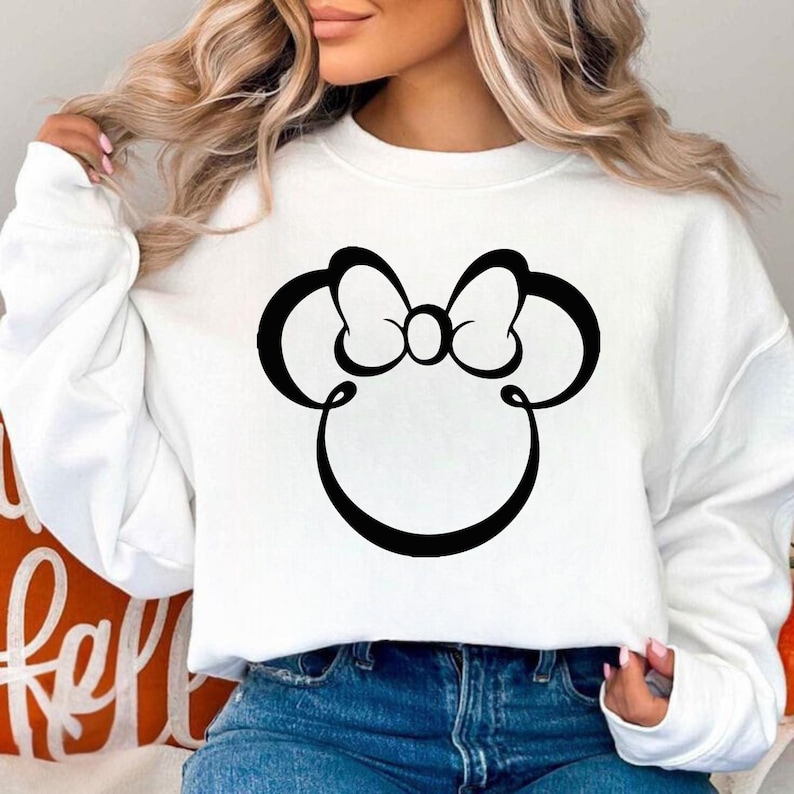 Pu&ograve; includere: Felpa bianca con un design a fiocco di Minnie Mouse nero. La grafica &egrave; un contorno stilizzato dell'iconico fiocco e delle orecchie di topo. La felpa &egrave; un top casual a maniche lunghe.