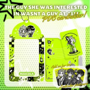 Op de afbeelding: Een neon groene PVC-kaarthouder met een bijpassend koord, met cartoon illustraties en de tekst "THE GUY SHE WAS INTERESTED IN WASNT A GUY AT ALL!". Bevat ook een lenticulaire fotokaart en een extra kaart.