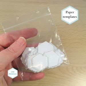 May include: A clear plastic bag filled with white paper hexagon templates. The bag is labelled "Paper templates".