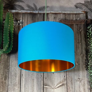 Lampenkap van topaasblauwe katoenen trommel met voering van koper- of goudfolie. Handgemaakt op bestelling in het Verenigd Koninkrijk met 12 verschillende maten om uit te kiezen