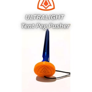Könnte beinhalten: Ein orangefarbener und blauer Ultraleicht-Zeltnagel-Schieber mit einer schwarzen Schnur. Das Werkzeug hat einen blauen Griff und eine orangefarbene Basis mit einem dreieckigen Design. Der Text "ULTRALIGHT Tent Peg Pusher" befindet sich über dem Werkzeug.