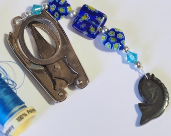 Small folding scissors with decorative beaded fob, blue borealis beads and a silver charm.