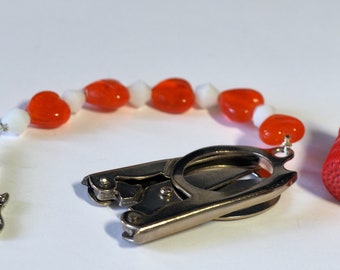 Small folding scissors with decorative beaded fob, red heart beads and a silver charm.