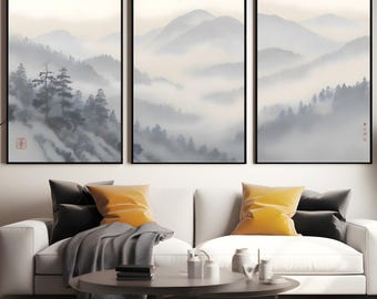 May include: Three framed landscape art prints showing misty mountain scenes with trees in grey and white. The artwork is displayed above a white sofa with yellow and black cushions.