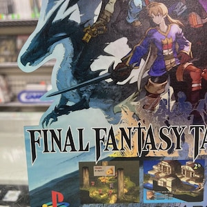 May include: A promotional poster for Final Fantasy Tactics, featuring a blue dragon, characters with swords, and the PlayStation logo. The poster has the game's title and images of gameplay.