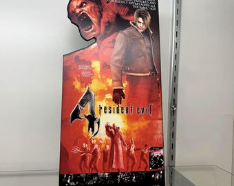 May include: A Resident Evil 4 promotional poster. The poster features a central image of a man in a brown jacket and red pants, with a large monster and other figures. The text reads "YOU WILL BE DISTURBED, SCARED, PANICKED AND COMPLETELY ENTERTAINED ALL THE SAME".