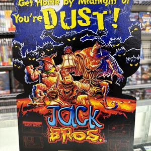 以下が含まれることがあります： ヴィンテージのJack Bros. Virtual Boyゲームディスプレイ。ディスプレイは、"Get Home by Midnight or You're DUST!"というテキストと、大きなカラフルな文字でゲームタイトルが書かれた濃い青色の背景が特徴です。アートワークは不気味なキャラクターと満月を描いています。