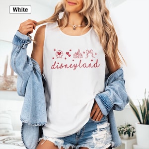 May include: White tank top with a red graphic of a castle, a Ferris wheel, hearts, and a bow. The text "disneyland" is written in red below the graphic.