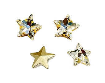 May include: Four star-shaped embellishments. Three are clear, faceted crystals with gold-colored metal backing. One is a solid gold-colored star. These decorative elements could be used for jewelry or craft projects.