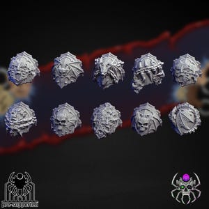 May include: A collection of ten gray, intricately designed, fantasy-themed helmet miniatures. Each helmet features a unique, detailed design, including skulls, chains, and bat-like wings. The image includes the text "pre-supported" and a spider logo.
