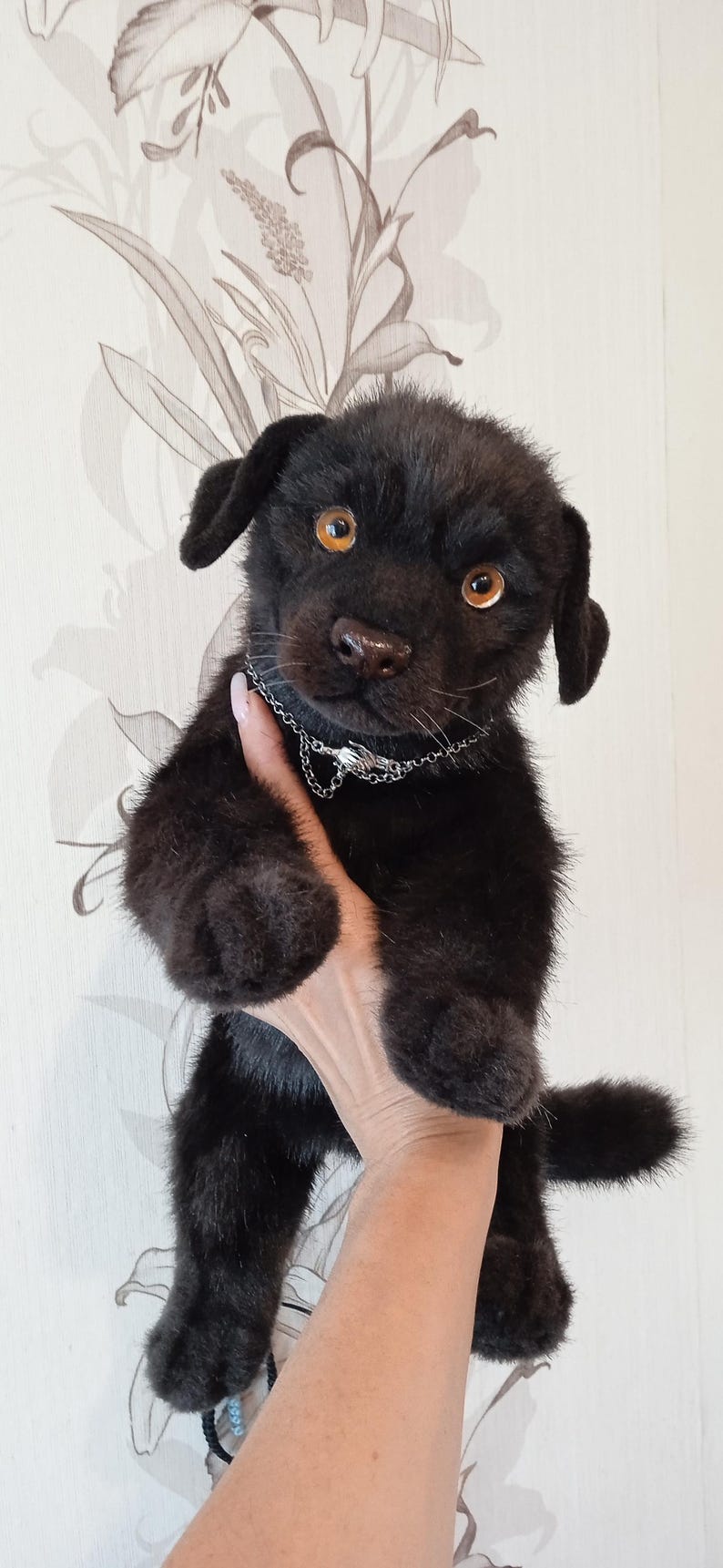 May include: A black plush puppy with amber eyes and a silver chain collar. The handmade stuffed animal has a realistic appearance, with detailed fur and a sweet expression. A unique gift for dog lovers.