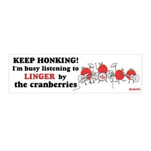 May include: White bumper sticker with the text "KEEP HONKING! I'm busy listening to LINGER by the cranberries." Features a cartoon band of red cranberries playing instruments. The band includes a drummer, two guitarists, and a microphone.