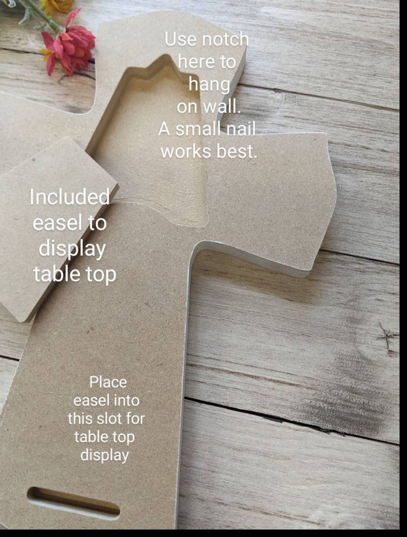 May include: A wooden cross with a notch for hanging on a wall and an included easel for tabletop display. The text on the cross reads: "Use notch here to hang on wall. A small nail works best." and "Included easel to display table top."
