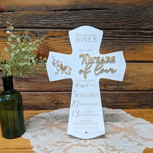 Pu&ograve; includere: Una croce di legno bianco con un'iscrizione dorata che celebra 70 anni d'amore. L'iscrizione include i nomi Tom e Lavon Jones, la data 2 novembre 1953 e il numero di figli, nipoti e pronipoti. La croce &egrave; decorata con un piccolo disegno di uccelli.