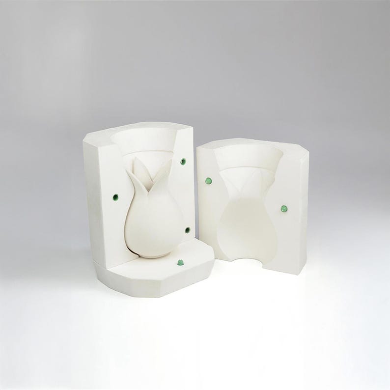 May include: Two-piece white ceramic mold for making a vase shaped like a flower bud.