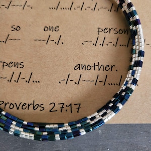 May include: A blue and silver beaded bracelet with the text "Proverbs 27:17" and the phrase "so one person another."