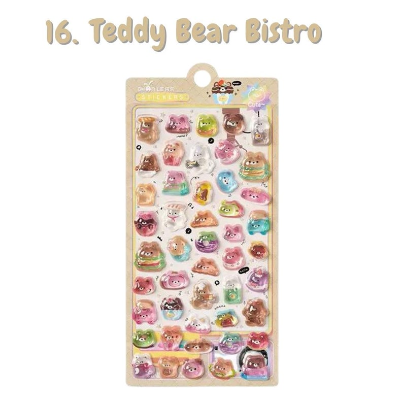 Może przedstawiać: Prostokątny arkusz naklejek z napisem 16. Teddy Bear Bistro zawierający liczne małe, błyszczące, wielokolorowe naklejki z misiami z kresk&oacute;wek w r&oacute;żnych pozach, jedzeniem i napojami na jasnobrązowym podkładzie z otworem do zawieszenia.