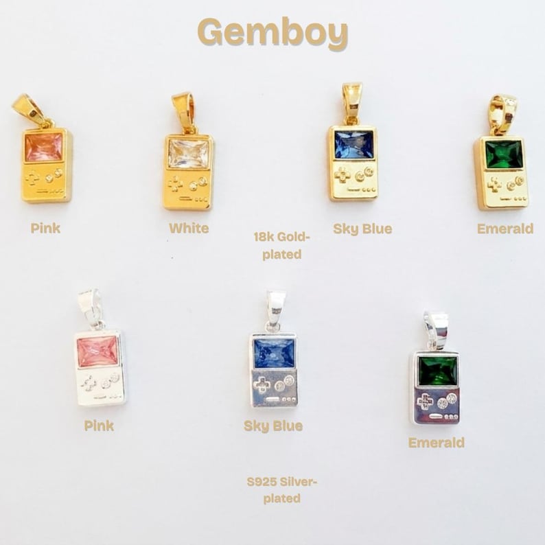 May include: A collection of Gemboy pendants shaped like handheld game consoles. The top row features 18k gold-plated pendants with pink, white, sky blue, and emerald rectangular gemstones. The bottom row shows S925 silver-plated pendants in pink, sky blue, and emerald.