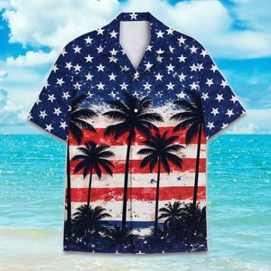 Könnte beinhalten: Kurzärmeliges Button-Down-Hemd mit patriotischem Design. Das Hemd hat einen blauen Hintergrund mit weißen Sternen, rot-weißen Streifen und schwarzen Palmen. Das Hemd ist so gestaltet, dass es wie die amerikanische Flagge aussieht.