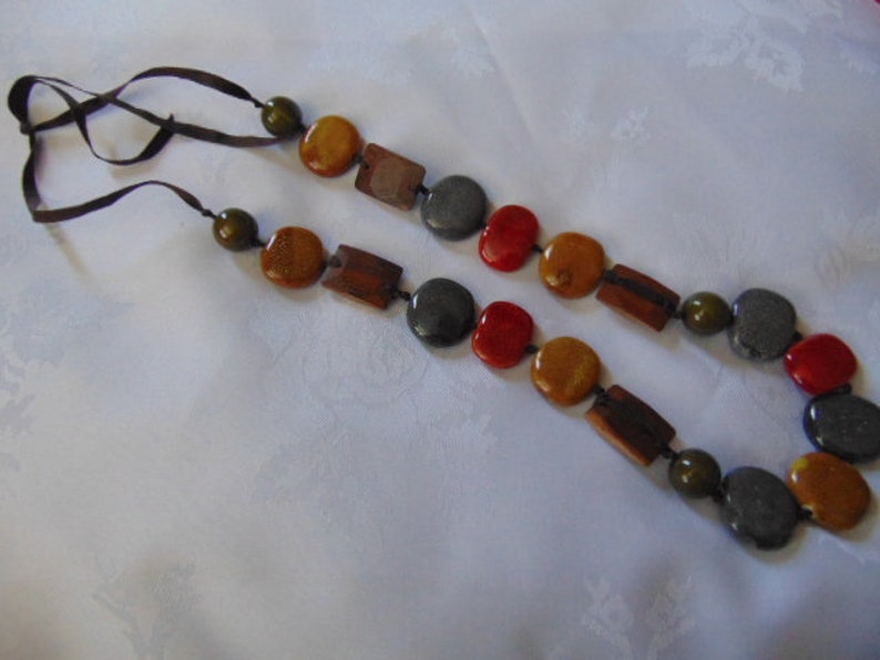 lovely long heavy multi coloured polished stone necklace on a dark brown ribbon 36 inches long
