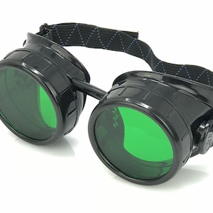 May include: Black steampunk goggles with green lenses and a black elastic band.
