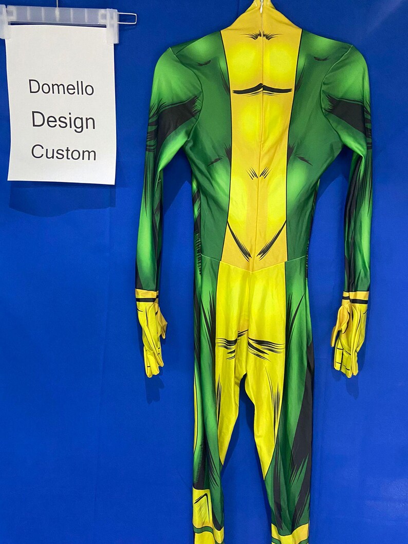 Op de afbeelding: Groen en geel spandex pak met een comic-stijl print. Het pak heeft een hoge hals en lange mouwen. De tekst "Domello Design Custom" is zichtbaar op een wit bord.