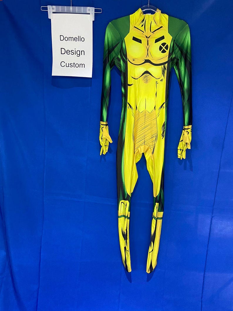 Op de afbeelding: Geel en groen spandex jumpsuit met een stripfiguurontwerp. Het personage heeft een grote X op zijn borst.