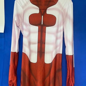 Puede incluir: Un traje de cuerpo entero rojo y blanco con un patr&oacute;n de panal. El traje tiene cuello alto y mangas largas.