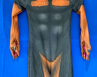 May include: A full-body costume featuring a gorilla design. The costume is primarily black with brown accents on the arms, chest, and legs. The arms end in brown gloves with pink accents, and the costume is hanging against a blue background.