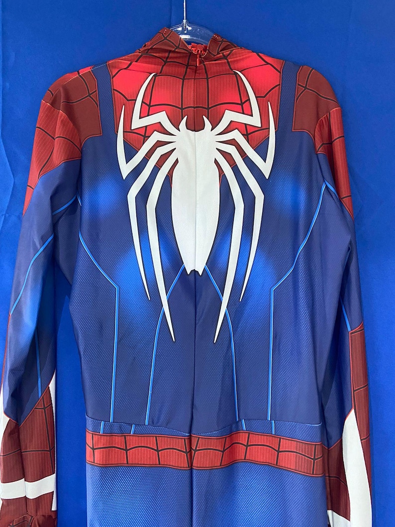 May include: A blue and red Spiderman costume with a white spider logo on the back. The costume has a zipper down the back.