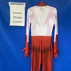 Puede incluir: Un body blanco y rojo hecho a medida con la parte superior blanca y la inferior roja. El body tiene mangas largas y un cuello alto. El texto "Domello Design Custom" es visible en un cartel blanco en el fondo.