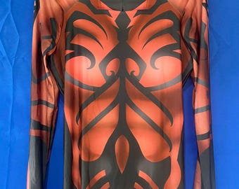 May include: A red and black long-sleeved bodysuit with a tribal pattern. The bodysuit has a high neck and a zipper in the front.