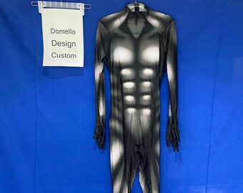 May include: Black and white long-sleeved bodysuit with a muscle-like pattern. The bodysuit has a high neck and long sleeves. The text "Domello Design Custom" is visible on a white sign.
