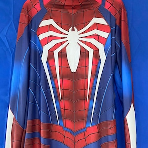 May include: A red and blue Spiderman costume with a white spider logo on the chest. The costume has a zipper in the back and long sleeves.