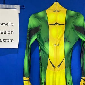Op de afbeelding: Een groene en gele spandex bodysuit met een zwart ontwerp. De achterkant van de bodysuit heeft een gele streep in het midden.