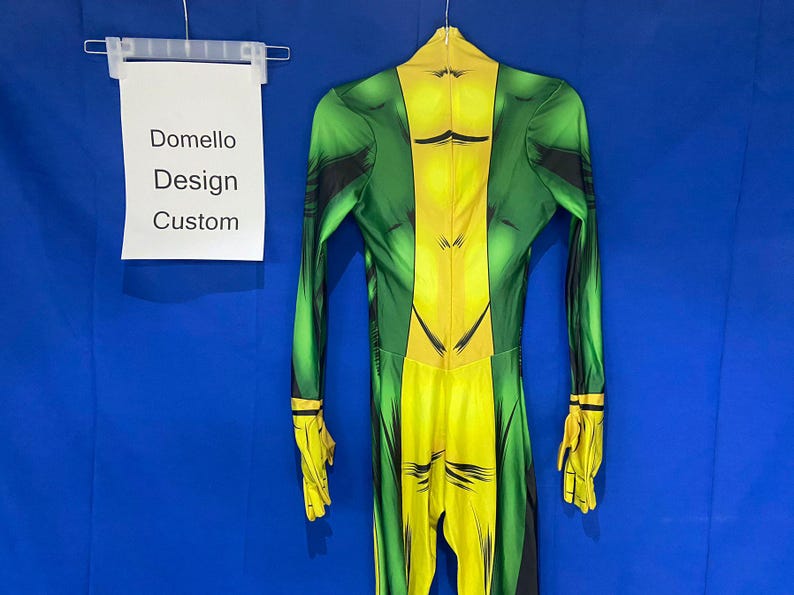 Op de afbeelding: Groen en geel spandex bodysuit met een bedrukt ontwerp. Het pak heeft een rits aan de achterkant en een label met de tekst "Domello Design Custom".