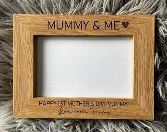 May include: A rectangular wooden picture frame with the text "MUMMY & ME" and a heart symbol at the top. The bottom of the frame reads "HAPPY 1ST MOTHER'S DAY MUMMY" and "Love from Tommy".