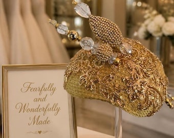 Fascinator dorato con applicazioni in pizzo dorato. Include 2 spille per cappello.