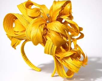 Tocado grande amarillo estilo Kentucky Derby con plumas y adornos de pedrería.