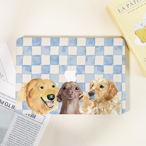 May include: Laptop case with a watercolour design of three dogs: two golden retrievers and a brown chihuahua. The background has a blue and white chequered pattern. A white Apple logo is visible.