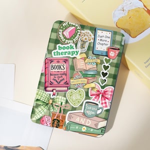 May include: A green and white plaid sticker sheet with various book-themed stickers. Stickers include a pink book, a stack of books, a coffee cup, and the text "book therapy." Other stickers include daisies, bows, and hearts.