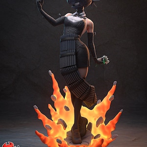 Peut inclure: Une figurine stylisée représentant un personnage à tête noire en forme de casque, aux dents acérées et au dos épineux. Le personnage porte un haut noir, une jupe à panneaux verticaux et de longs gants, tenant une petite fleur blanche sur une base de flammes orange vif.