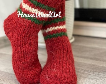May include: Red wool socks with green and white stripes. The socks are knitted and have a fuzzy texture. The text "House Wool Art" is visible on the socks.