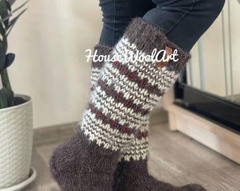 May include: A pair of brown wool socks with a patterned design in white and red. The socks are knee-high and have a textured appearance. The text "HouseWoolArt" is visible on the socks.