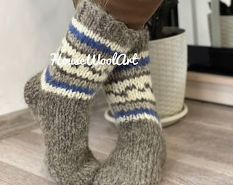 May include: Pair of grey wool socks with blue and white stripes. The socks are knitted and have a fluffy texture.
